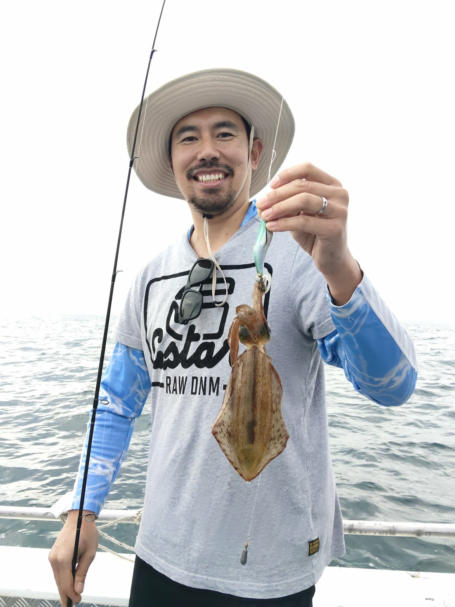 Smiling angler holding a squid from the lure