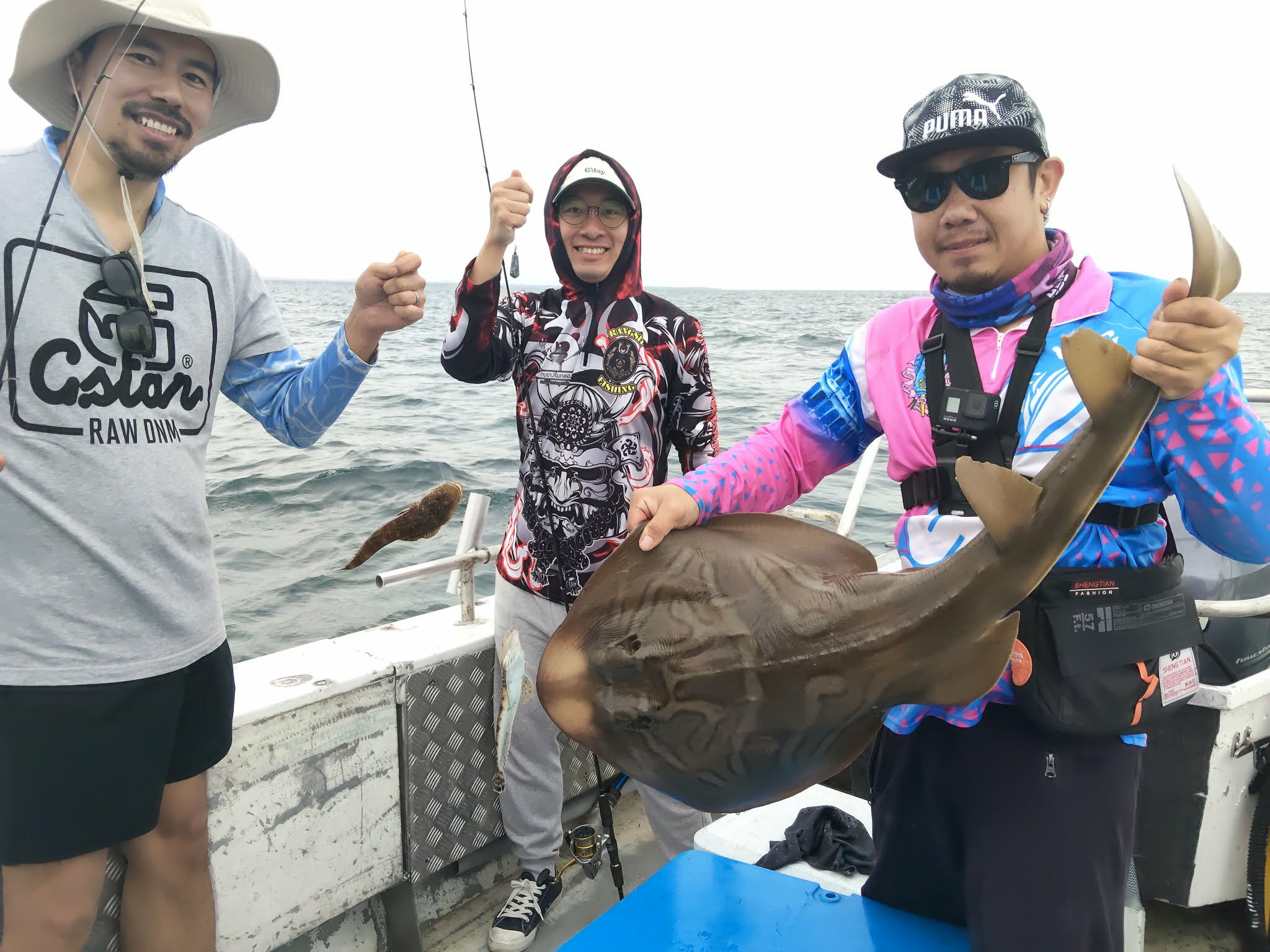 Three guests enjoying a varied catch aboard the boat